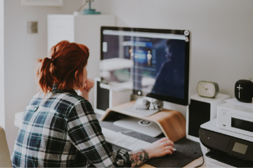 Jeune femme regardant un webinaire Jira Service Desk sur son ordinateur